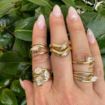 Elegant 14K yellow gold and diamond rings, offering a stunning display of light and modern minimalistic sophistication. Multiple rings on models hand.