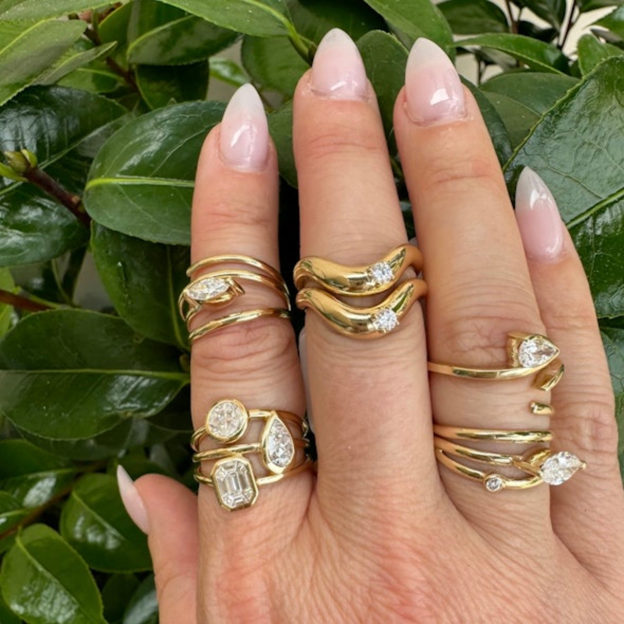 Elegant 14K yellow gold and diamond rings, offering a stunning display of light and modern minimalistic sophistication. Multiple rings on models hand.