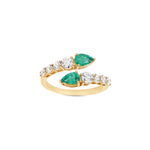 Graceful 14K yellow gold bypass ring featuring radiant graduated diamonds and vibrant pear-cut emeralds, offering timeless sophistication and a captivating silhouette, making it the perfect gift. Close up of angled front view. 