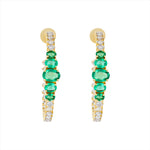 Major statement 14K yellow gold hoop earrings featuring 3.15ct of vibrant graduated emeralds and 3.05ct of G-H VS diamonds, sized at 1.5 inches for maximum impact and brilliance.