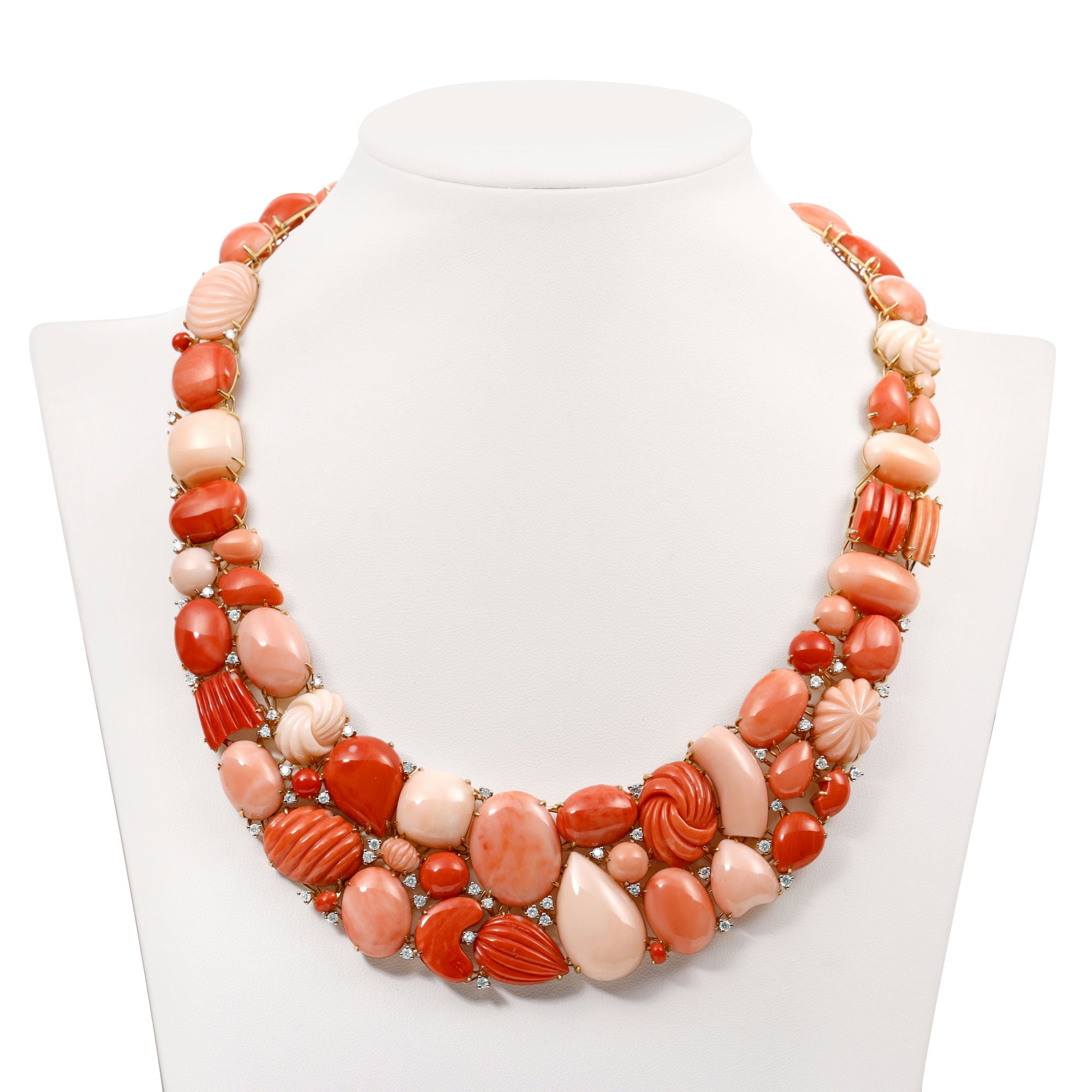 Exquisite 18K yellow gold bib necklace featuring hand-carved coral gemstones in varying shapes and sizes, accented by delicately placed diamonds for added brilliance, creating a striking and timeless statement piece. Front view of necklace. 