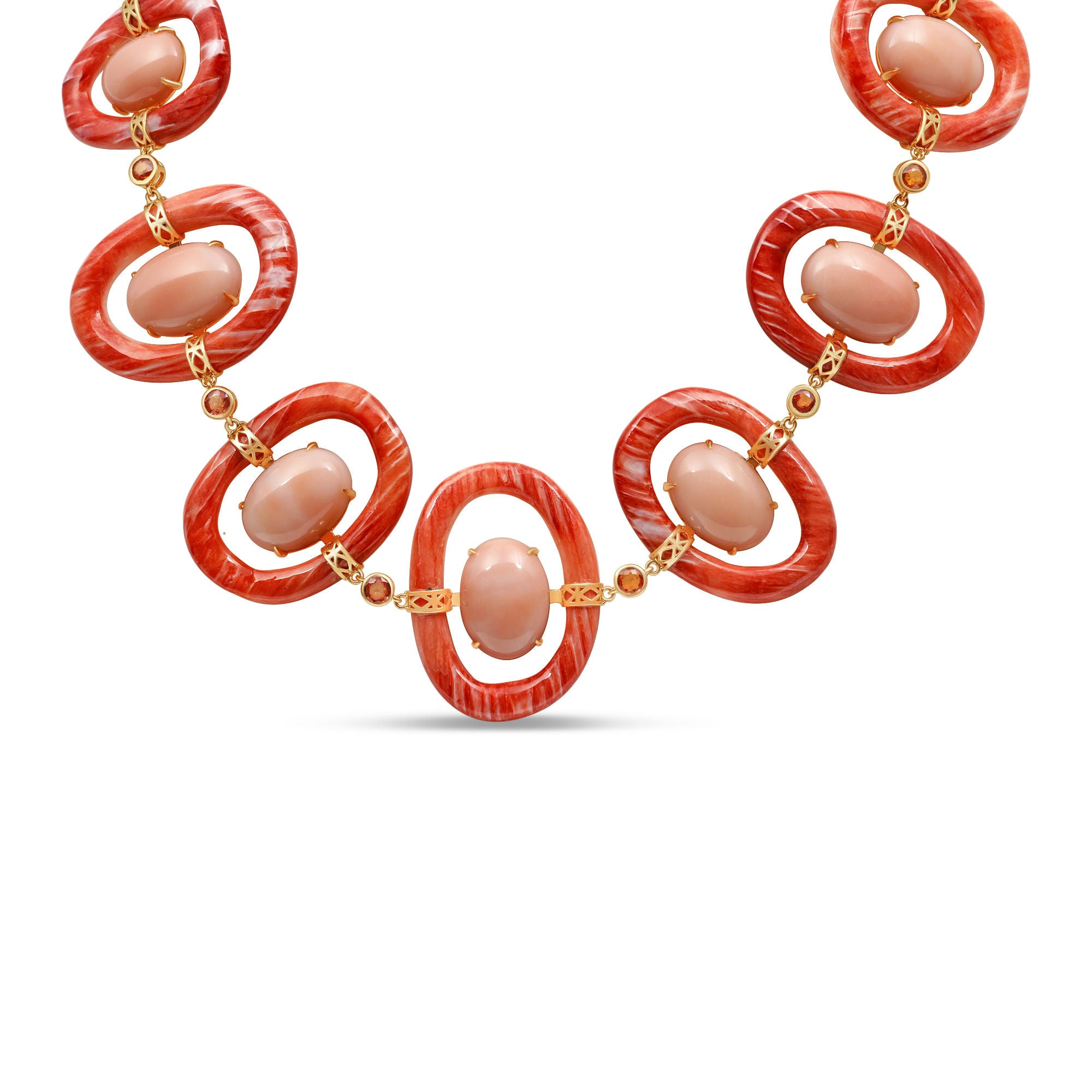 Striking 18K yellow gold link necklace featuring hand-carved orange shell links, smooth pink coral cabochons, and delicate orange sapphires, blending warm hues with masterful craftsmanship for a bold yet sophisticated statement piece. Close up detail of coral, gold and cabochons. 