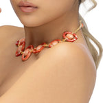 Striking 18K yellow gold link necklace featuring hand-carved orange shell links, smooth pink coral cabochons, and delicate orange sapphires, blending warm hues with masterful craftsmanship for a 