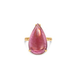 Exquisite 18K yellow gold ring featuring a breathtaking hand-carved pink tourmaline cabochon with a luminous glow, accented by vibrant yellow sapphires for a striking contrast of warmth and brilliance. Top view close up of stone and prong setting.