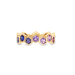 Captivating 18K yellow gold eternity ring featuring vibrant hexagon-cut sapphires in a spectrum of colors, offering a playful yet elegant touch to any jewelry collection. Of blues and purples. 