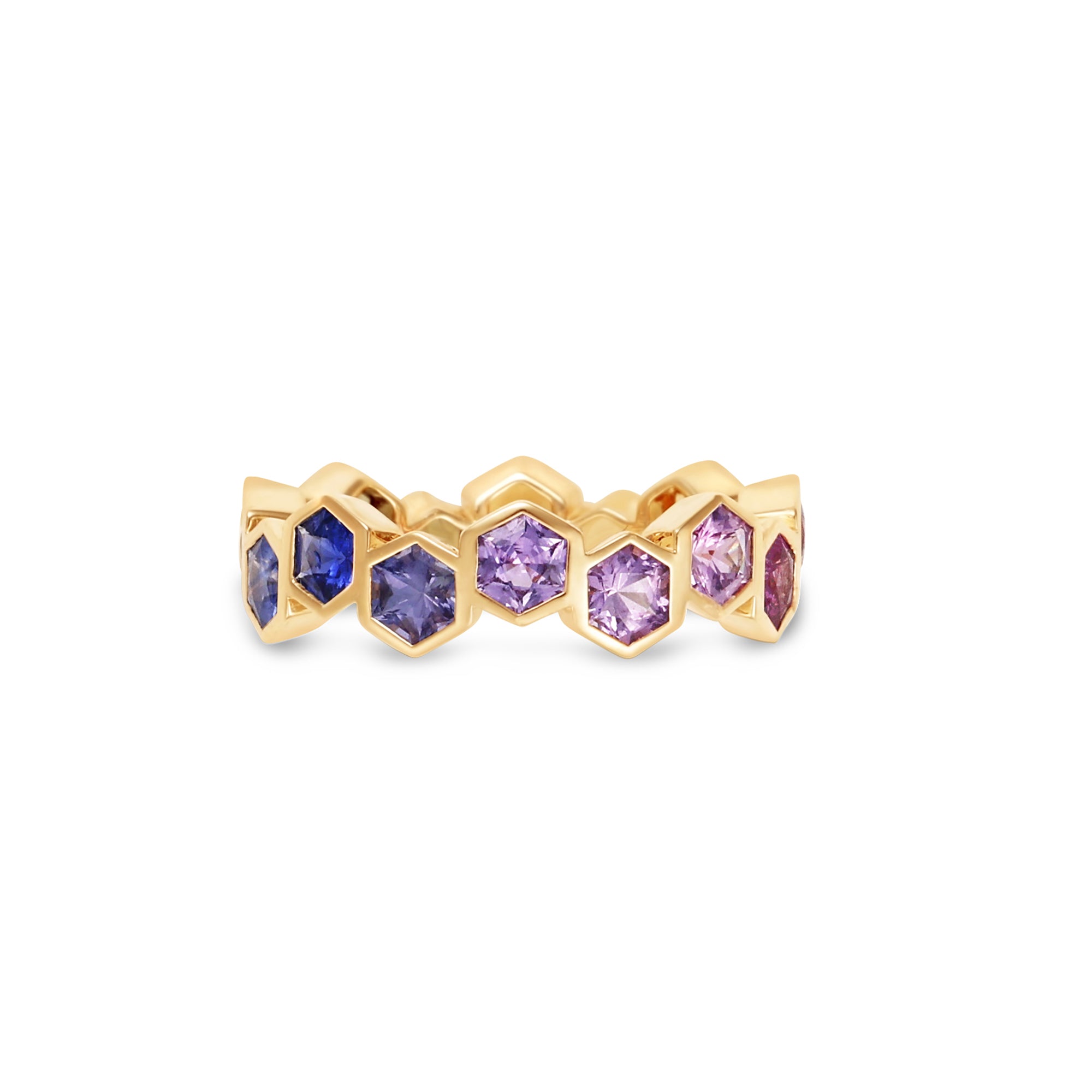 Captivating 18K yellow gold eternity ring featuring vibrant hexagon-cut sapphires in a spectrum of colors, offering a playful yet elegant touch to any jewelry collection. Of blues and purples. 
