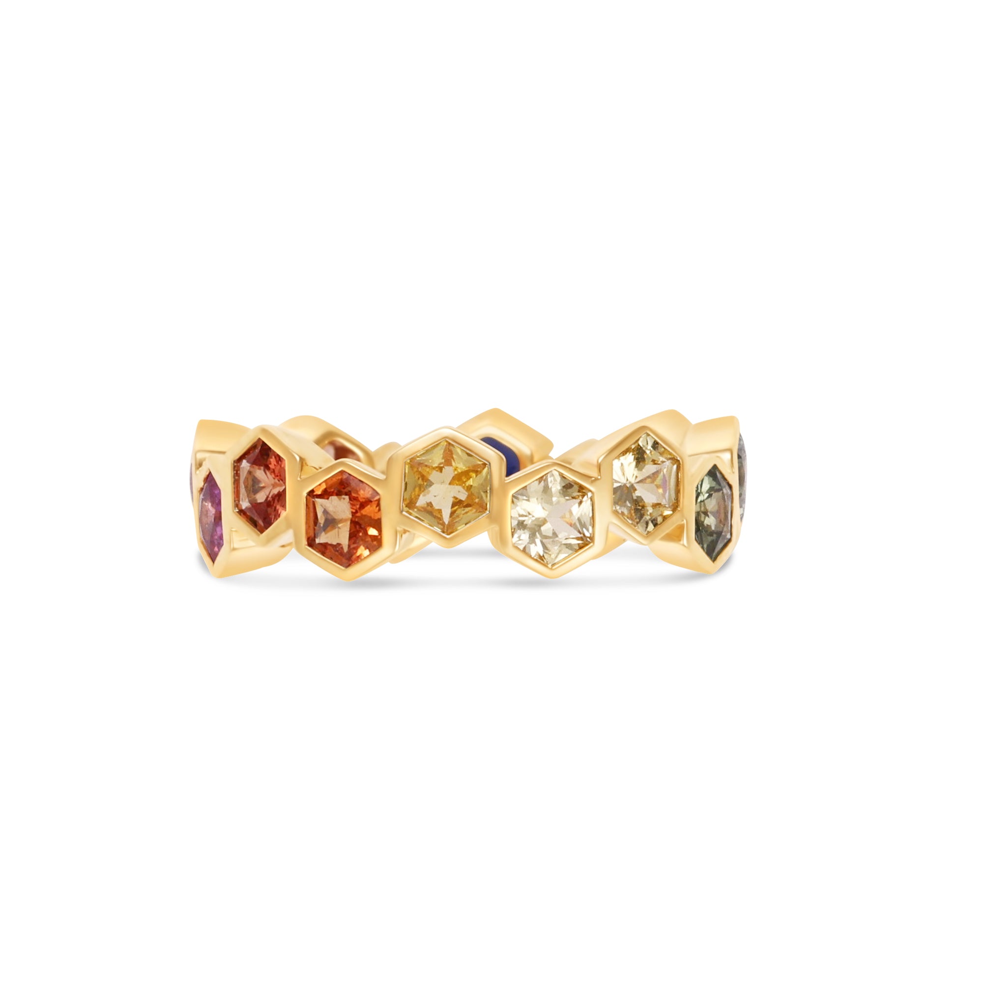 Captivating 18K yellow gold eternity ring featuring vibrant hexagon-cut sapphires in a spectrum of colors, offering a playful yet elegant touch to any jewelry collection. Close up, reds and yellows. 