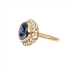 Elegant 14K yellow gold cocktail ring featuring a 10.71ct London blue topaz surrounded by a sparkling diamond halo, set in a sophisticated anemone-inspired basket design.