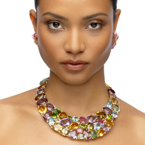 Extraordinary one-of-a-kind bib necklace crafted in 18K yellow gold, featuring a dazzling mosaic of semi-precious gemstones including amethyst, citrine, peridot, topaz, and tourmaline, designed to make a bold and elegant statement.
