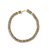 Modern slinky bracelet crafted in sleek 14K yellow Italian gold, featuring sparkling pavé black diamond rondelles for a bold and unique statement of elegance. Open clasp top down image