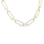 Luxurious 14K yellow gold elongated paperclip chain necklace adorned with dazzling pavé diamonds, offering a sleek and sophisticated design that effortlessly enhances any ensemble. Close up, detail. 