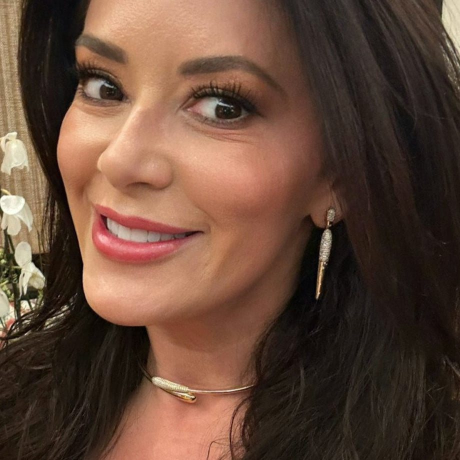 Sleek 14K yellow gold spike dangle earrings featuring shimmering pavé and scattered diamonds, offering a bold yet sophisticated accessory with an elegant edge. Owner Elizabeth Wahler in Left Ear 