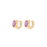 Enchanting pink sapphire huggie earrings crafted in 14K yellow gold, featuring vibrant oval-cut pink sapphires for a perfect blend of charm and sophistication, suitable for any occasion. Side view, close up.