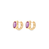 Enchanting pink sapphire huggie earrings crafted in 14K yellow gold, featuring vibrant oval-cut pink sapphires for a perfect blend of charm and sophistication, suitable for any occasion. Side view, close up.