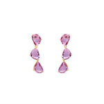 Dazzling pink sapphire drop earrings featuring three luminous sapphires totaling approximately 2ct, elegantly set in 14K yellow gold for a timeless blend of charm and sophistication. Front view, close up. 