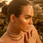 Dazzling pink sapphire drop earrings featuring three luminous sapphires totaling approximately 2ct, elegantly set in 14K yellow gold for a timeless blend of charm and sophistication. On model, right ear. 