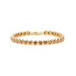 Stunning orange sapphire tennis bracelet featuring round bezel-set sapphires in 14K gold, offering a bold yet elegant statement of luxury.