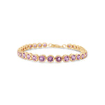 Charming pink sapphire tennis bracelet featuring vibrant round bezel-set sapphires in 14K yellow gold, designed for elegance and romance.