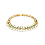 Striking 14K yellow gold bracelet featuring bezel-set vibrant emeralds in edgy, spiked links, blending modern sophistication with a bold, daring aesthetic.