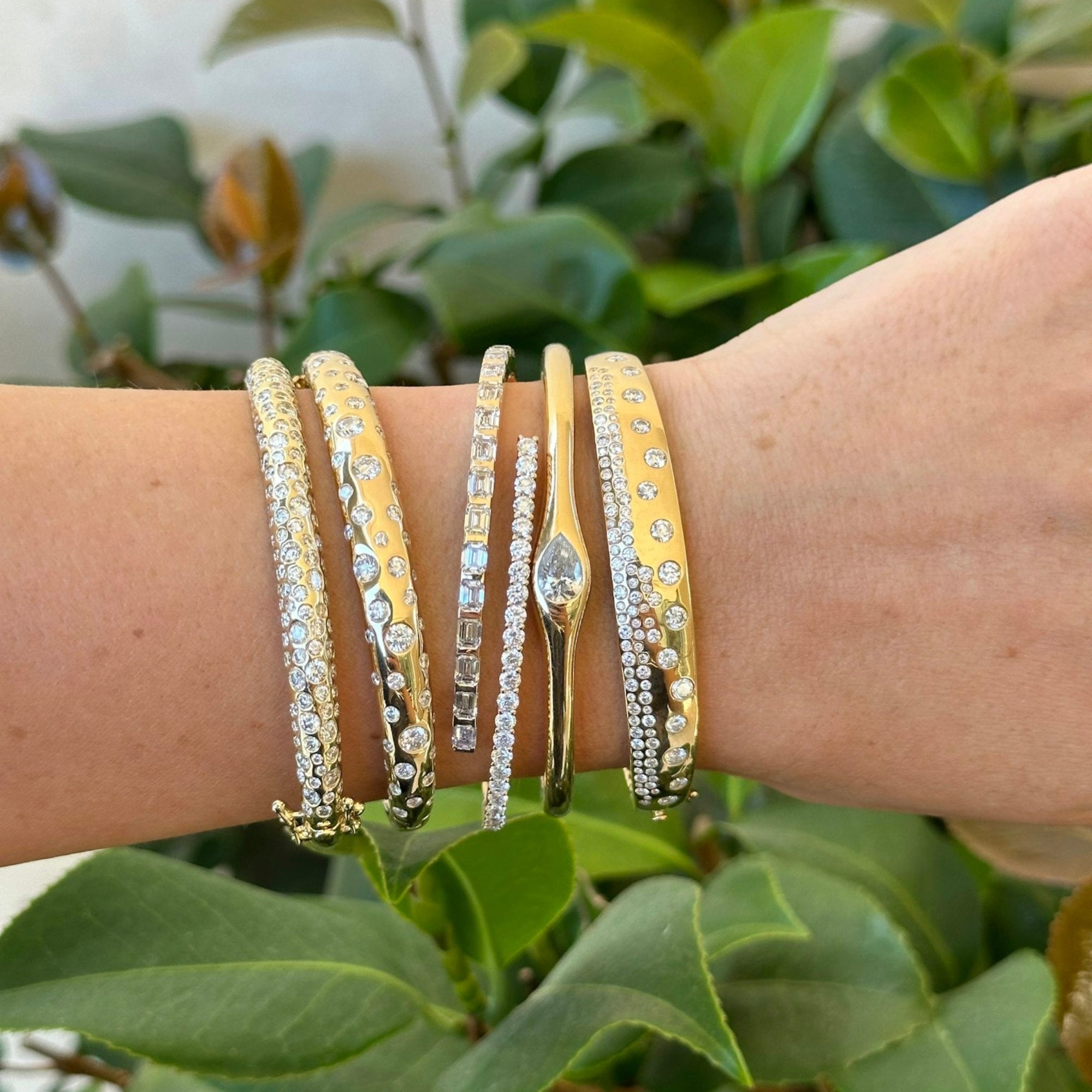 Elegant 14K yellow gold tapered bangle bracelet featuring 1.1ct of scattered diamonds, combining a sleek silhouette with timeless sparkle.