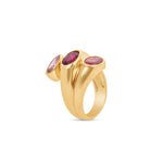 Unique 14K yellow gold statement ring featuring three bezel-set tourmaline stones in delicate shades of pink, blending elegance with bold color for a timeless look. Angled view. 