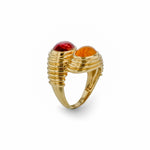 Striking 14K yellow gold bypass ring featuring vibrant orange spessartite and pink tourmaline cabochons, set in a fluted band for a bold and opulent statement. Side angle. 