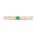 Refined 14K yellow gold bangle featuring a centered emerald flanked by sparkling diamonds, combining classic elegance with vibrant color for a timeless bracelet design.