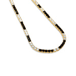 Striking tennis necklace crafted in 14K yellow gold, featuring alternating prong-set black and white diamonds, exuding bold sophistication and timeless charm. Close up image