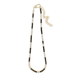 Striking tennis necklace crafted in 14K yellow gold, featuring alternating prong-set black and white diamonds, exuding bold sophistication and timeless charm.