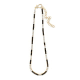 Striking tennis necklace crafted in 14K yellow gold, featuring alternating prong-set black and white diamonds, exuding bold sophistication and timeless charm.
