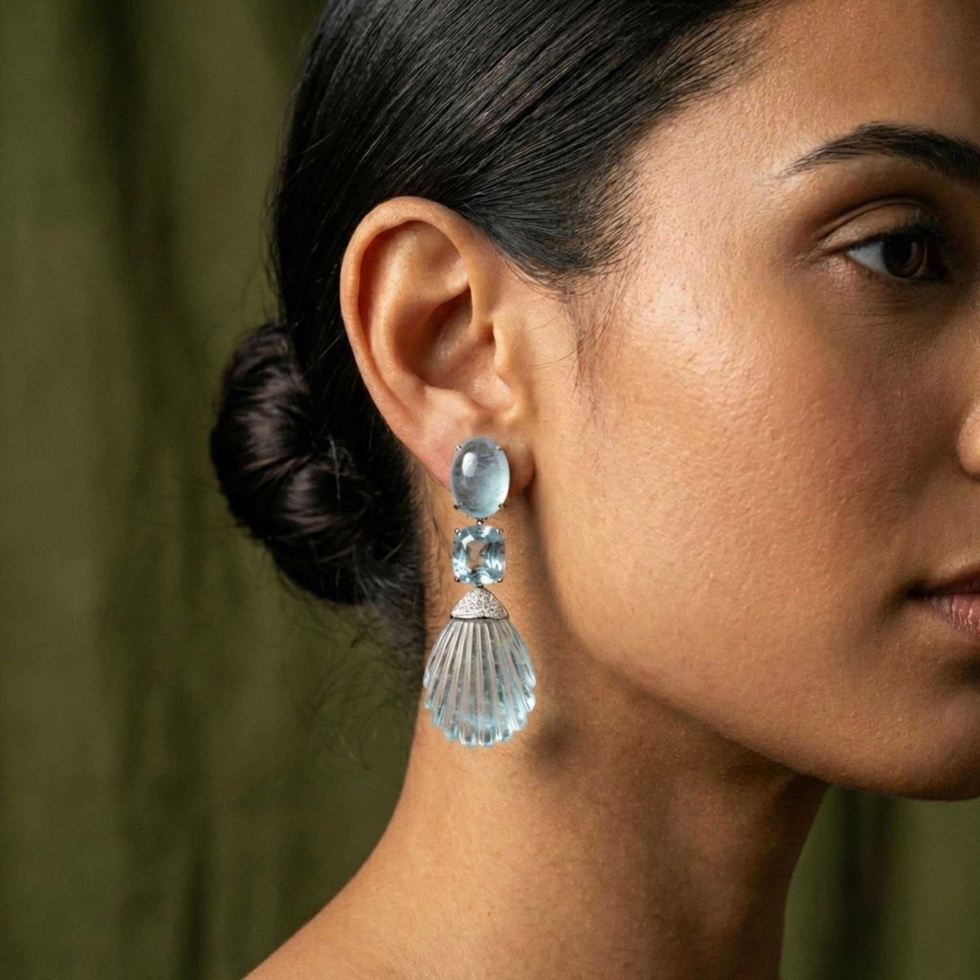 These Hand-Carved Aquamarine and Diamond Drop Earrings are a sculptural ode to light, water, and craftsmanship. Carved from over 110 carats of luminous aquamarine, each gemstone flows with organic elegance, suspended in a cool-toned setting of 18K white gold. Accented by pavé-set diamonds, the composition captures movement and serenity in equal measure.