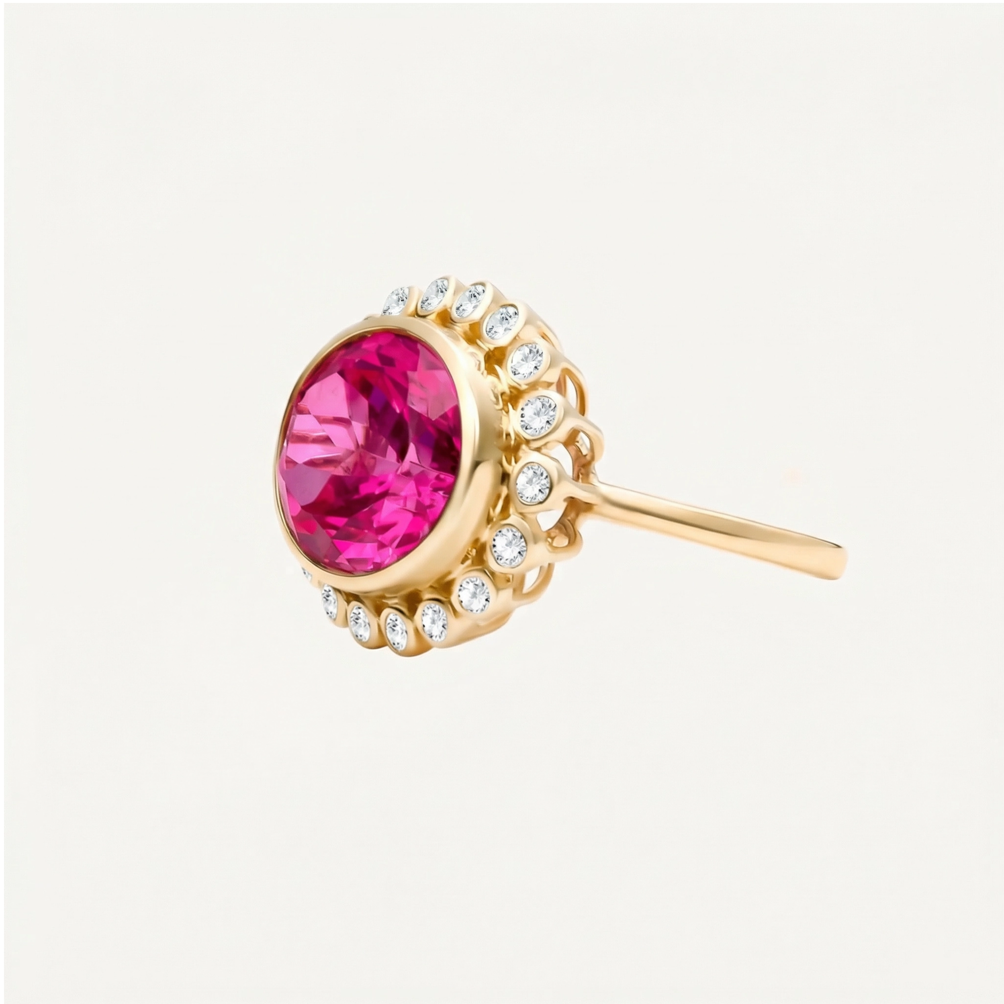 Hot pink topaz in an oval cut set in a bezel sitting above a halo of bezel set round diamonds in an over the top cocktail ring. 