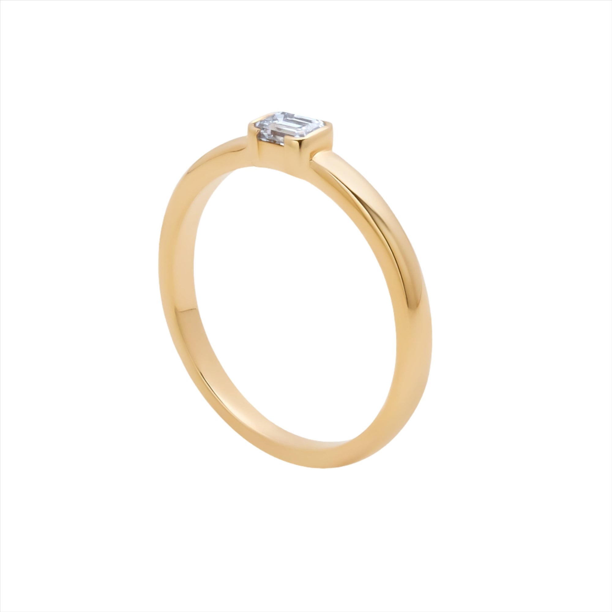 Stackable 14K yellow gold ring featuring a 0.29ct emerald cut diamond solitaire, with a sleek, minimalist profile measuring 3.1mm by 3.6mm and a total weight of 2.42g.