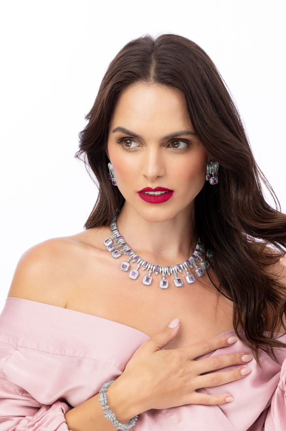 Woman wearing a sparkling necklace and earrings on a white background
