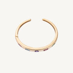 Detail view of the original multicolor bangle in 14K yellow gold, showing the five flush-set stone positions later reset with tanzanite.