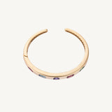 Detail view of the original multicolor bangle in 14K yellow gold, showing the five flush-set stone positions later reset with tanzanite.