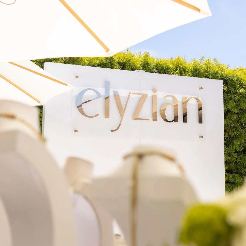 Elyzian Fine Jewelry elegant white brand signage at luxury trunk show event