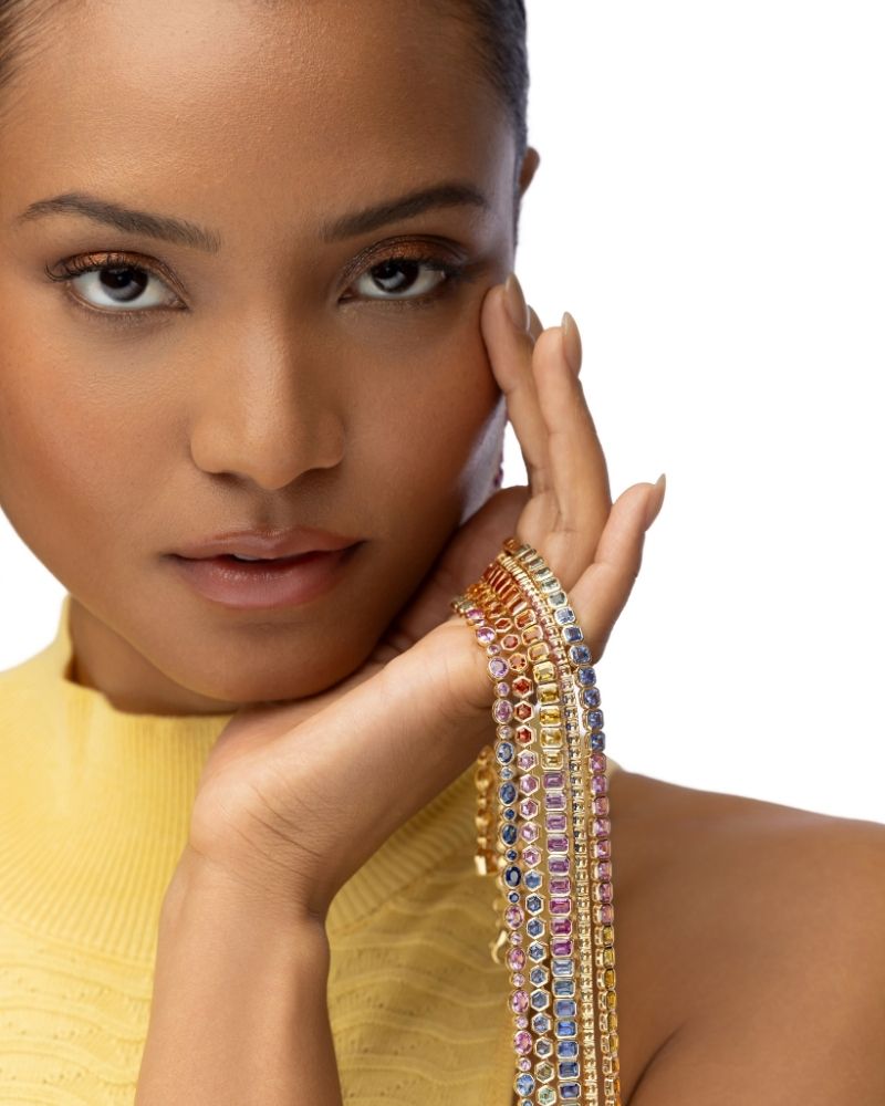Stack of colorful sapphire tennis bracelets with diamonds in 18k gold