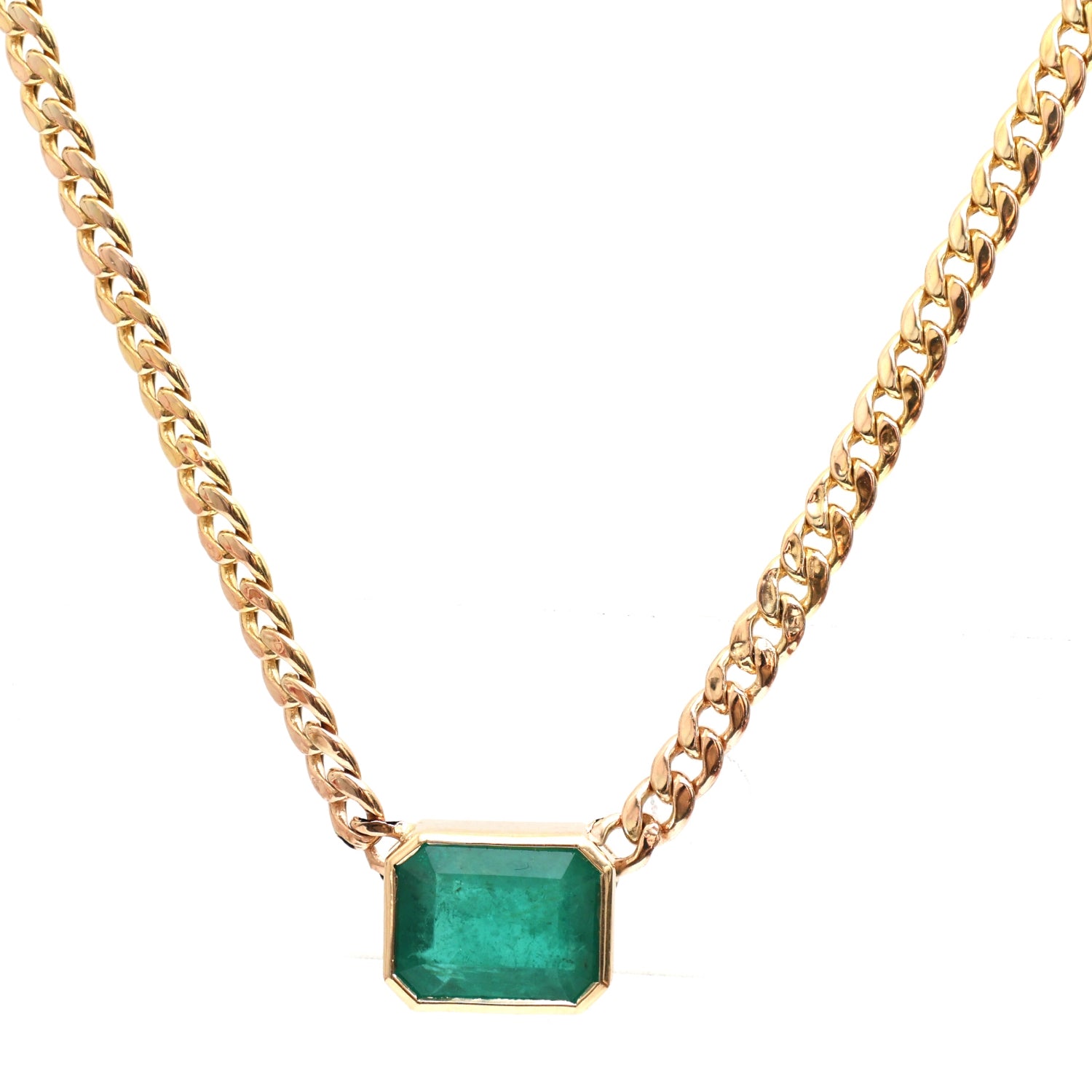An emerald-cut emerald curb chain necklace in 14k yellow gold featuring a 5.14ct bezel-set emerald pendant (10mm x 12mm x 7mm) on a 17.5" curb chain.