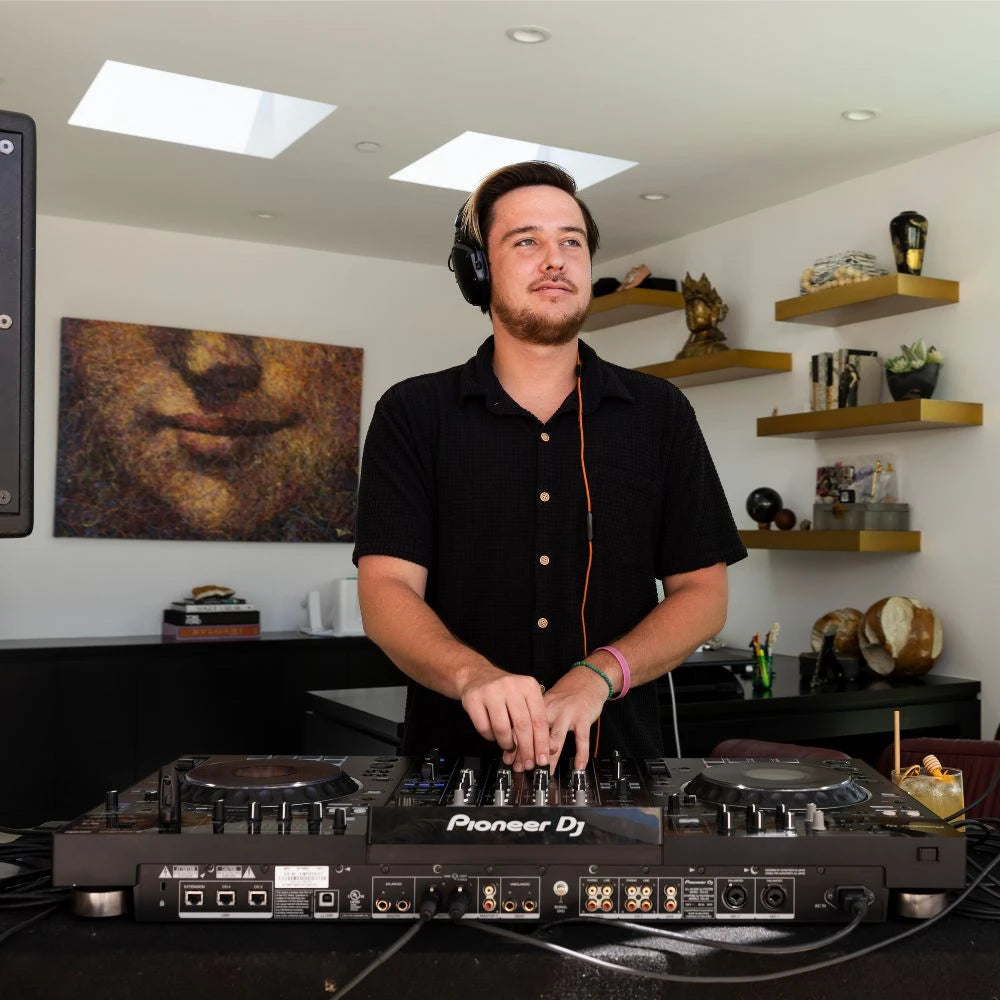 DJ providing entertainment at luxury event with professional audio equipment