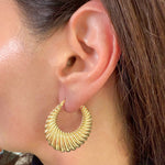 Modeled image on ear of Medium Fluted Saddle Hoop Earrings in 14K Yellow Gold by Elyzian