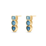 Angled view of a Pair of 14k yellow gold stud earrings featuring bezel-set London Blue, Swiss Blue, and Aquamarine gemstones in geometric shapes.