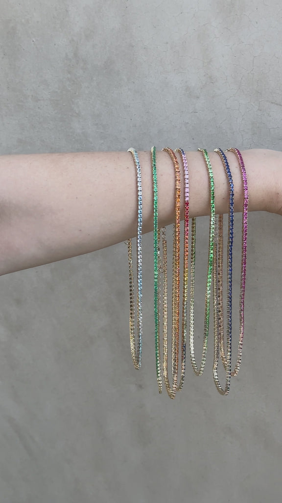Multiple gemstone tennis necklace in movement. Adjustable ombre tsavorite garnet tennis necklace featuring 22.37ct of vibrant green gemstones, elegantly set in yellow gold with a length range of 40cm to 46cm for a customizable fit.

