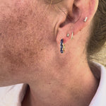 Luxurious tanzanite huggie earrings featuring vibrant gemstones in an elegant and versatile design, perfect for adding a pop of color to any outfit. 