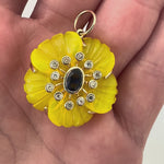 Azure Glow captures sunshine meeting ocean in one extraordinary piece. Six hand-carved yellow quartz petals, treated to achieve golden perfection, frame a faceted blue sapphire center.

At nearly 24 carats, these petals catch light like August afternoons. The 0.57-carat sapphire shows pure Ceylon blue, the kind that reminds you why sapphires remain eternal favorites. Diamonds surround this study in contrasts, adding brilliance to the joyful color story.