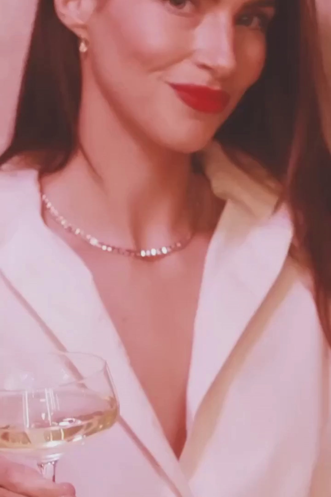 Model showcasing Diamond Halo and Pink Tourmaline Marquise Art Deco Ring in 18K Gold from Elyzian Fine Jewelry Valentine's Collection, close-up of hand with champagne glass