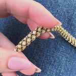 Luxurious 14K yellow gold rope bracelet featuring an intricate woven design accented with dazzling diamonds, blending timeless sophistication with modern brilliance for a stunning statement piece. Close up front view. 