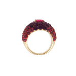 Angled view of A 14k yellow gold dome ring featuring a 1.32ct rubellite center framed by 4.95ct of rhodolite and 2.84ct of amethyst in a pavé setting.